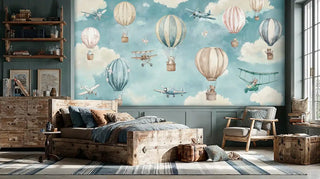 Whimsical airplane and balloon wall mural in soft pastels displayed in a rustic children's bedroom with reclaimed wood furniture and vintage suitcases