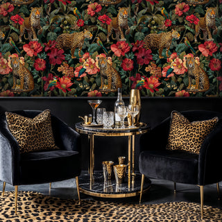 Wild leopard wallpaper with tropical blooms, shown in sophisticated lounge with velvet chairs