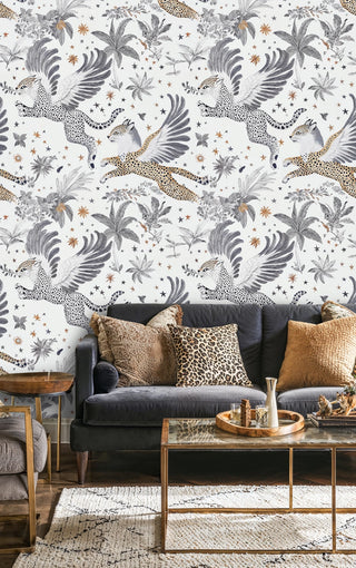 Winged leopard and star pattern wallpaper in a living room with dark velvet sofa and glass coffee table