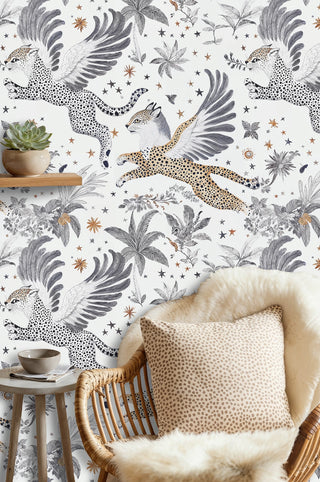 Winged leopard wallpaper with stars and palms in a boho nook with rattan chair and spotted cushion