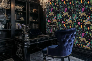 Winged leopard wallpaper with vibrant florals and stars in sophisticated home office with navy velvet chair