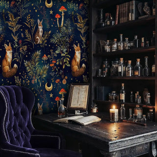 Woodland animal wallpaper with celestial elements displayed in dark study with vintage bottles and purple velvet chair