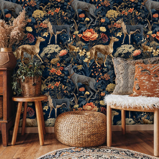 Woodland animal wallpaper with deer and botanical motifs in navy and gold, shown in boho living room with wicker furniture