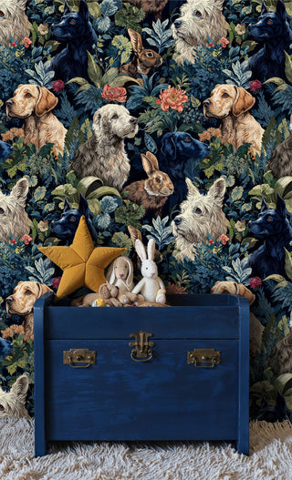 Woodland pet wallpaper featuring dogs and rabbits among coral florals on navy, shown in kids room with blue trunk